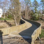 Vehicular bridge to private island, with living shoreline, beach, and riprap breakwater.