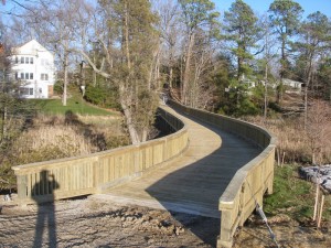 Vehicular bridge to private island, with living shoreline, beach, and riprap breakwater.